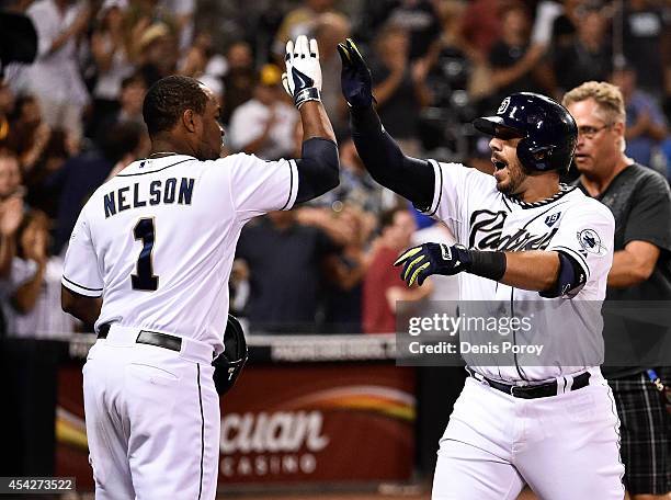 Rene Rivera of the San Diego Padres, right, is congratulated by Chris Nelson after he hit a solo home run during the ninth inning of a baseball game...