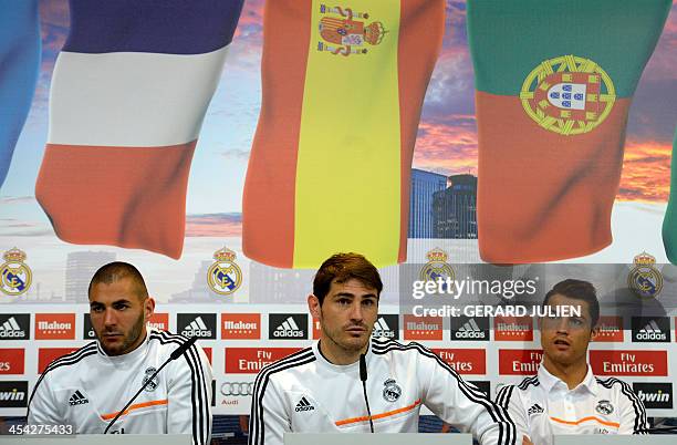 Real Madrid's Portuguese forward Cristiano Ronaldo and French forward Karim Benzema listen to Spanish goalkeeper Iker Casillas as they give a press...