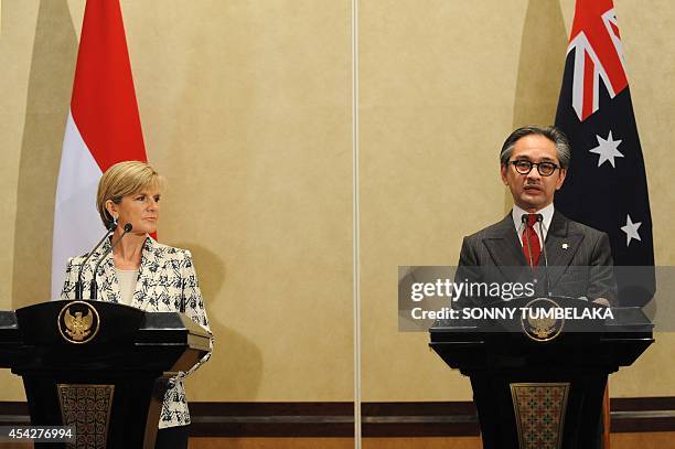 Australia's Foreign Minister Julie Bishop listens as her Indonesian counterpart Marty Natalegawa speaks to journalists during a press conference...