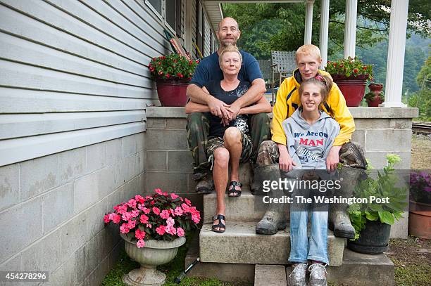 Michael Estep, with his wife Vada, their son, Jobe, and his live-in girlfriend Kristen Goodman, pose at their home August 13, 2014 in Logan, WV.