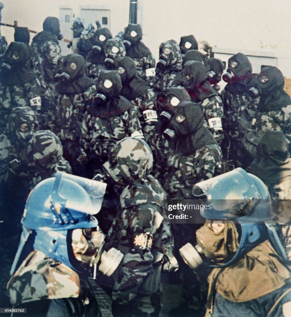 Japanese Riot Control Riot policemen wearing gas masks stand by during a dawn raid at a ...