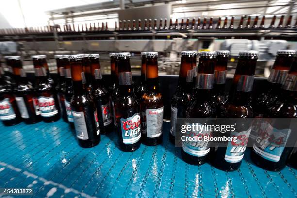 Bottles of Coors Light beer, manufactured by Molson Coors Brewing Co., move along the production line at the company's brewery and bottling plant in...