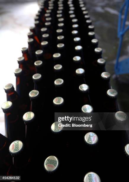 Bottles of Cobra beer, manufactured by Molson Coors Brewing Co., pass along the production line ahead of labeling at the company's brewery and...