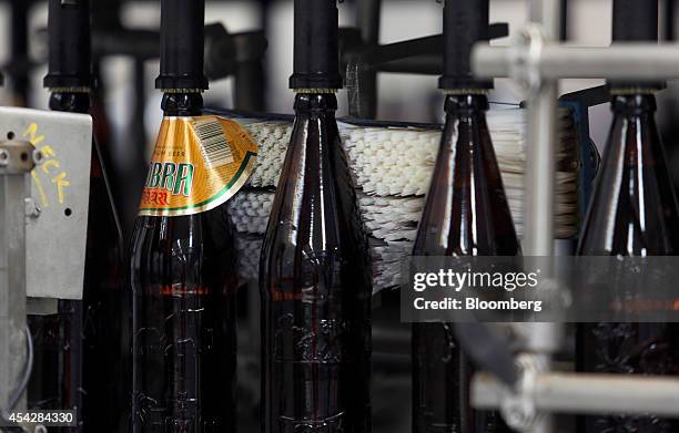 Bottles of Cobra beer, manufactured by Molson Coors Brewing Co., pass through a labeling machine at the company's brewery and bottling plant in...