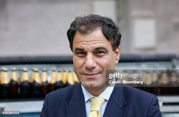 Karan Bilimoria, founder and chairman of Cobra Beer, poses for a photograph next to bottles of Cobra beer, manufactured by Molson Coors Brewing Co.,...