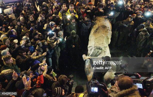 Protester breaks apart a statue of Lenin at a monument in his honor after it was pulled down during a mass rally called "The March of a Million" in...