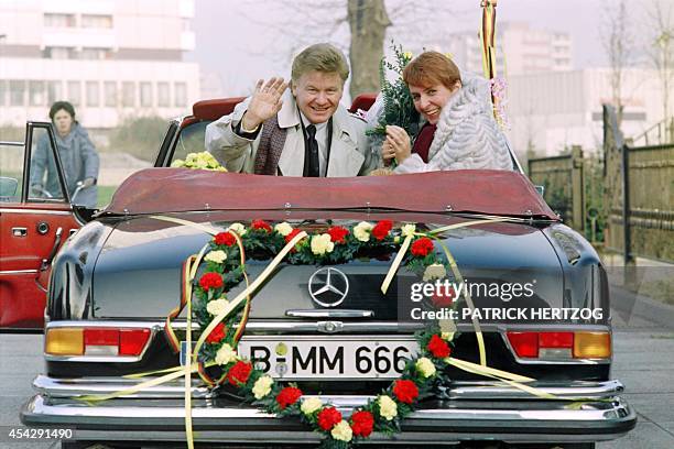 Marianne Kopper of East Berlin and her husband Wolfgang Spitz of West Berlin wave to photographers, on November 20, 1989 after their wedding ceremony...