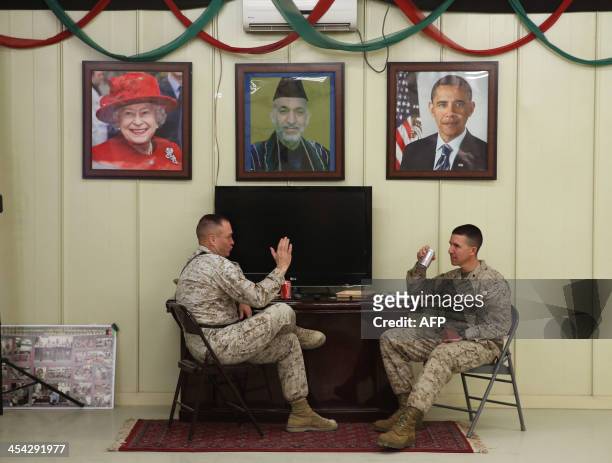 Marines Lt. Col. Clint Benfield and Col. Ben Watson talk underneath pictures of Queen Elizabeth, Afghan President Hamid Karzai and President Barack...