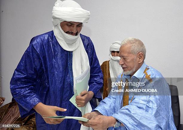 Leader of the Ansar Dine delegation Algabass Ag Intalla and Ahmed Ould Sidi Mohamed exchange a document as Ethnic Tuareg and Arab militias from Mali...