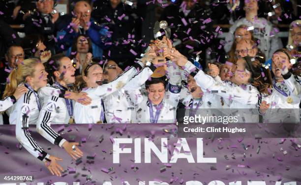 Germany captain Jasmin Sehan holds up the trophy as her teammates celebrate their victory during the UEFA European Women's Under - 17 Championship...