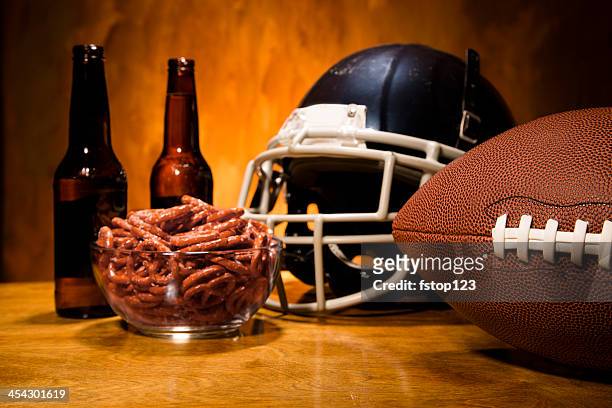 sports:  football helmet, ball on table.  pretzels and beer. championship game. - american football game stockfoto's en -beelden