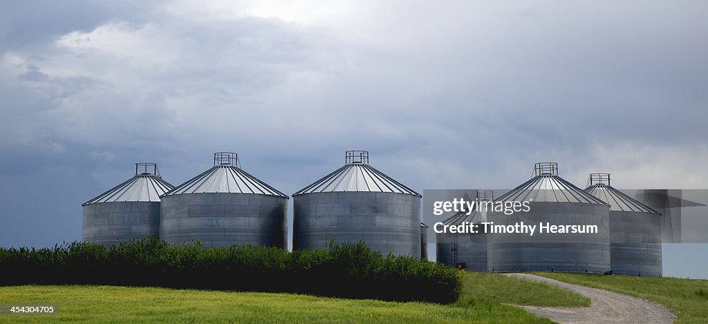 Grain bins with stormy sky beyond