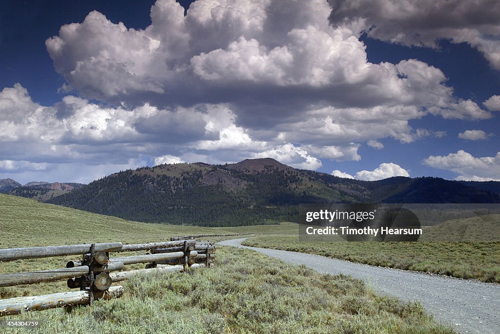 Gravel road and split rail fence thru ranch land