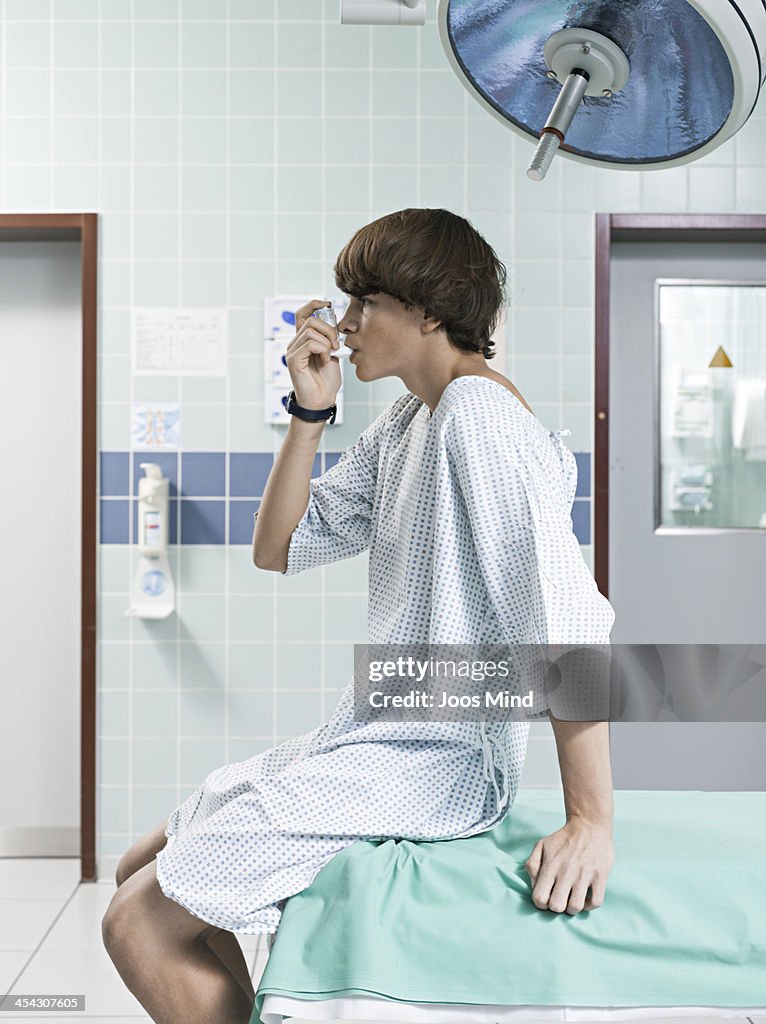 Young boy using asthma inhaler