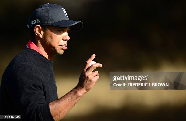 Golfer Tiger Woods gestures after sinking his putt at the fifth hole during final round of the Northwestern Mutual World Challenge golf tournament at...