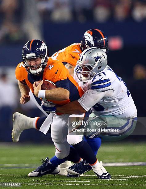 Zac Dysert of the Denver Broncos is sacked by Stephen Goodin of the Dallas Cowboys in the second half of their preseason game at AT&T Stadium on...