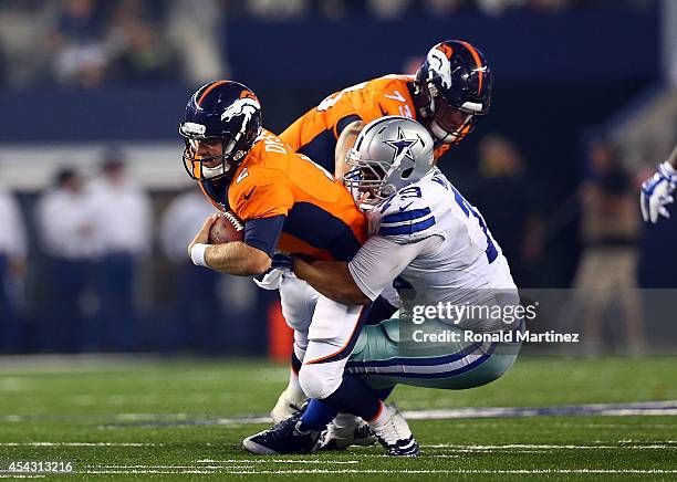 Zac Dysert of the Denver Broncos is sacked by Stephen Goodin of the Dallas Cowboys in the second half of their preseason game at AT&T Stadium on...
