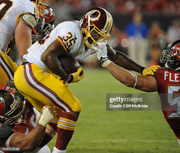 Running back Lache Seastrunk of the Washington Redskins is pulled down by the face mask middle linebacker Dane Fletcher of the Tampa Bay Buccaneers...