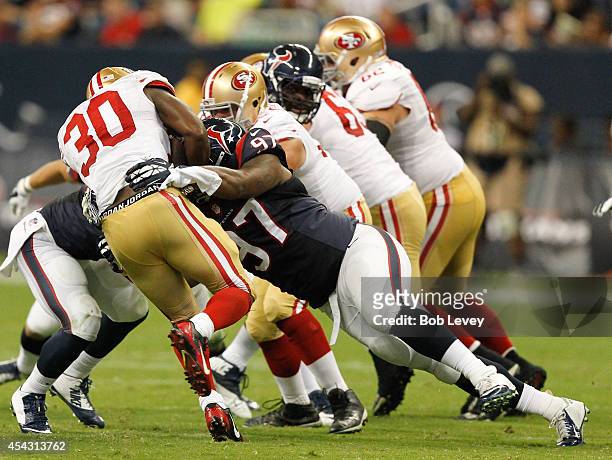 Alfonso Smith of the San Francisco 49ers is stopped by Jeoffrey Pagan of the Houston Texans at Reliant Stadium on August 28, 2014 in Houston, Texas.