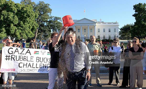 Palestinian rights activist gets a bucket of rubble on his head as he takes part in the Rubble Bucket challenge to show solidarity with Palestinians...