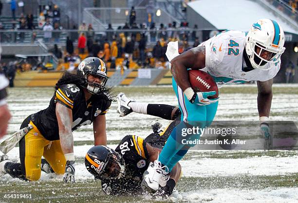 Charles Clay of the Miami Dolphins breaks a tackle against Troy Polamalu and Cortez Allen of the Pittsburgh Steelers to score a 12 yard touchdown...