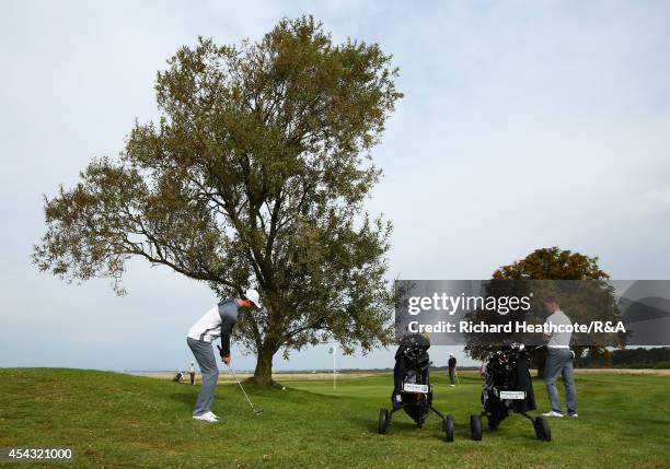 Tim Harry of GB&I chips around a tree onto the 9th green in his match with Rowan Lester against Adam Blomme and Marcus Kinhult of Europe during the...