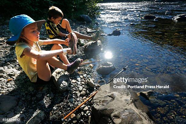 Madeline and Nathan Kallin put on their shoes after crossing a stream while hiking near Gulf Hagas, a registered national landmark along the...