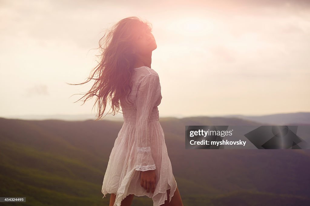 A beautiful woman walking around a mountainside