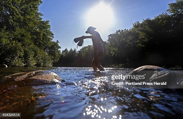 Emily Kallin carries her shoes across a stream while hiking with her family at Gulf Hagas, a registered national landmark along the Appalachian Trail...