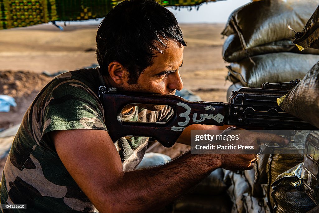 Peshmerga soldiers watch and wait for the Islamic state to...