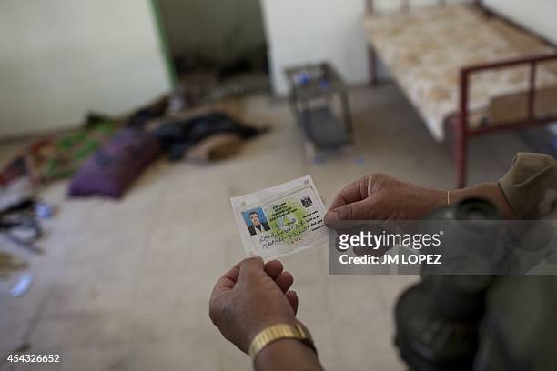 Kurdish Peshmerga fighter looks at Iraqi ID inside a house during a patrol in Jalawla, 130 kilometres northeast of Baghdad and only 30 from the...