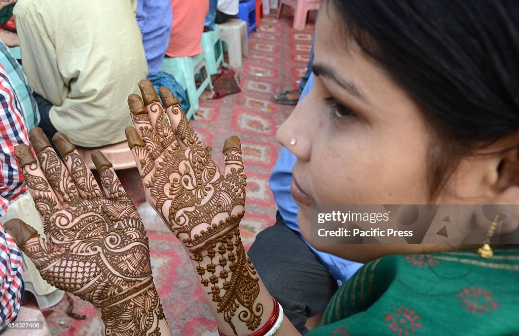 Women with their hands tattooed with henna on the eve of the...