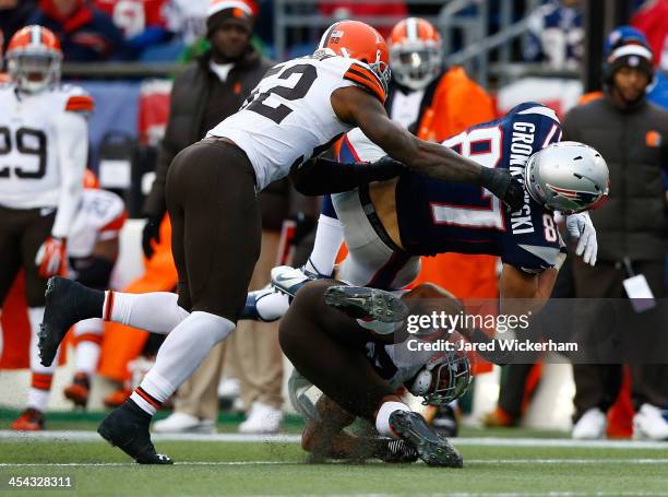 Rob Gronkowski of the New England Patriots catches a pass before being hit by T.J. Ward and D'Qwell Jackson of the Cleveland Browns in the third...