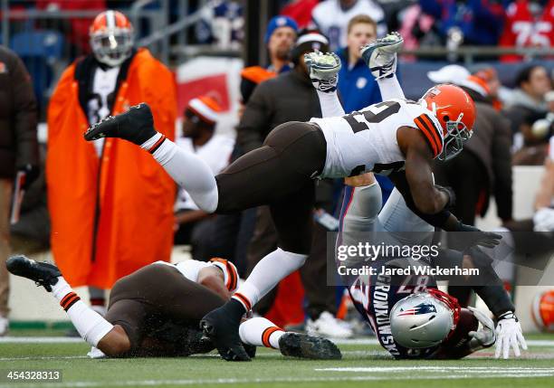 Rob Gronkowski of the New England Patriots catches a pass before being hit by T.J. Ward and D'Qwell Jackson of the Cleveland Browns in the third...