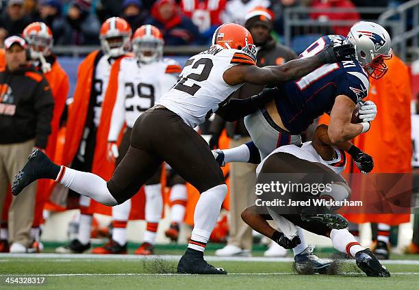 Rob Gronkowski of the New England Patriots catches a pass before being hit by T.J. Ward and D'Qwell Jackson of the Cleveland Browns in the third...