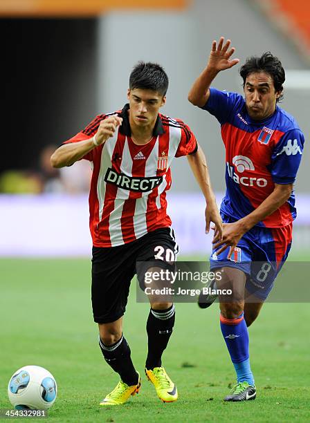 Joaquin Correa of Estudiantes fights the ball with Marcos Gelabert of Tigre during a match as part of 19th round of Torneo Inicial 2013 at Ciudad de...