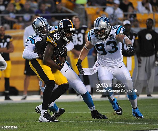 Wide receiver Darrius Heyward-Bey of the Pittsburgh Steelers is tackled by cornerback Melvin White and linebacker Chase Blackburn of the Carolina...