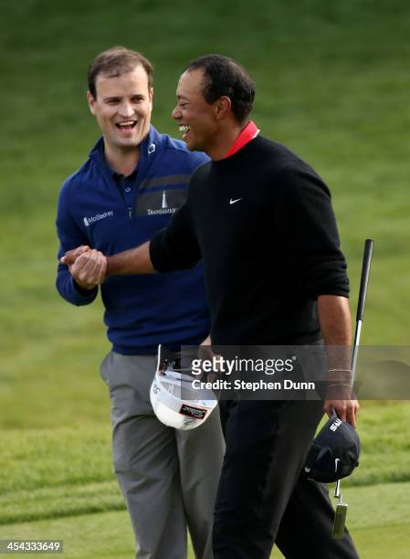 Zach Johnson and Tiger Woods shake hands after they finished regulation play in a tie during the final round of the Northwestern Mutual World...