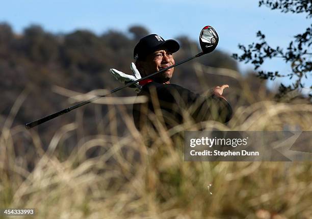 Tiger Woods drops his club after hitting his tee shot on the 11th hole during the final round of the Northwestern Mutual World Challenge at Sherwood...