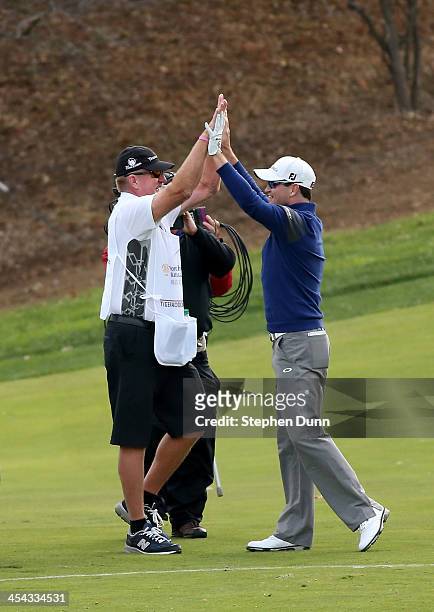 Zach Johnson celebrates with caddie Damon Greenl after holing out from the drop zone after going in the water on the 18th hole to force a playoff...