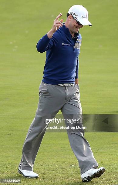 Zach Johnson waves after holing out from the drop zone after going in the water on the 18th hole to force a playoff during the final round of the...