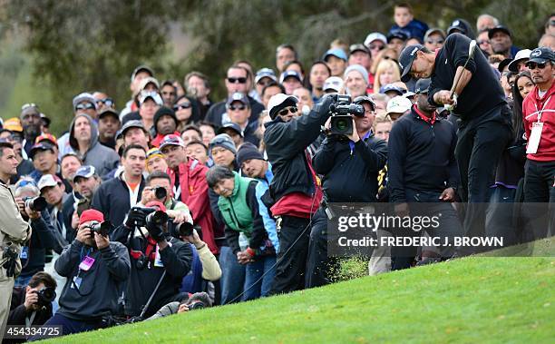 Fans watch as US golfer Tiger Woods plays a shot at the 18th hole during the final round of play at the Northwestern Mutual World Challenge golf...