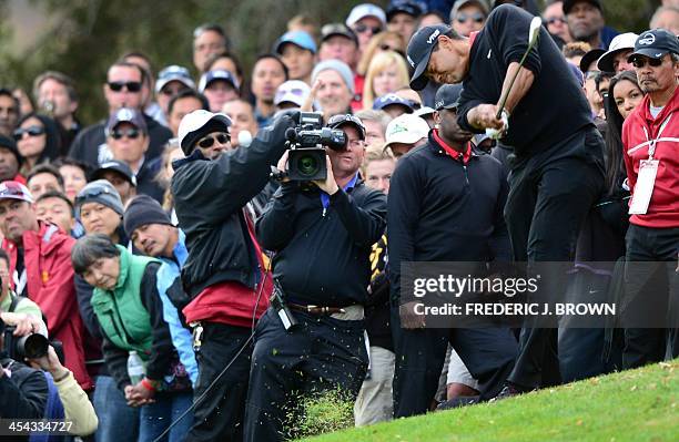 Fans watch as US golfer Tiger Woods plays a shot at the 18th hole during the final round of play at the Northwestern Mutual World Challenge golf...