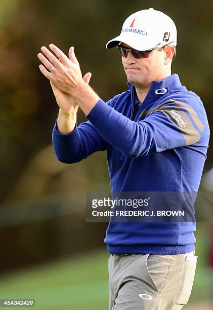 Golfer Zach Johnson acknowledges the crowd after sinking his putt on the green at the 18th hole during the final round of play ahead of a playoff...
