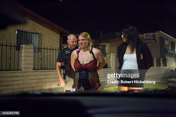 Vice squad officer with the Los Angeles Police Department, Sergeant Brian Gallagher, left, questions two women January 31, 2013 before they're...