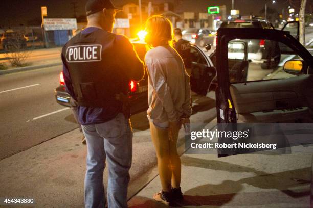 Year old girl in hand-cuffs is questioned February 2, 2013 by a vice squad policeman, Sergeant Brian Gallagher, with the Los Angeles Police...