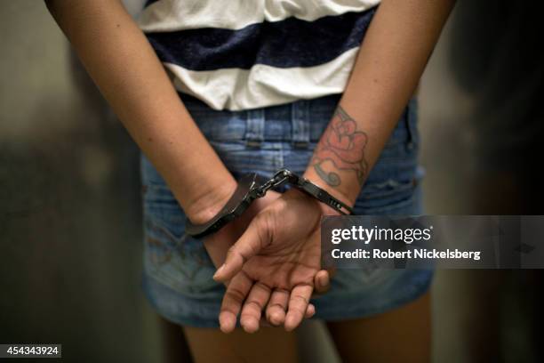 Year old girl in hand-cuffs is questioned February 2, 2013 by a vice squad policeman with the Los Angeles Police Department's South Central's 77th...