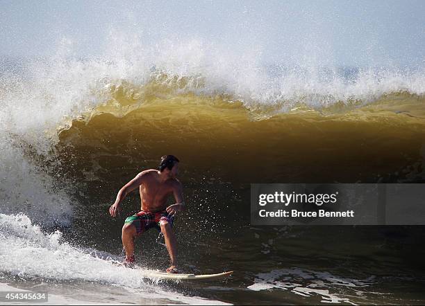 Surfers enjoy four to six foot swells off the Atlantic Ocean on August 28, 2014 in Long Beach, New York. Hurricane Cristobal is churning up larger...