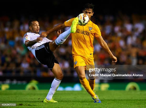 Ruben Vezo of Valencia competes for the ball with Roque Santa Cruz of Malaga during the La Liga match between Valencia CF and Malaga CF at Estadi de...