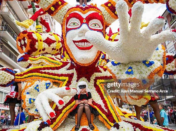 Girl sit atop a float decorated with flowers during the battle of the flowers parade on August 29, 2014 in Laredo, Spain.